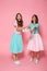 Full length photo of two overjoyed young woman dressed like children exchanging presents