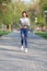 Full-length photo of a young woman runs in the city park. Concept of keeping fit and healthy lifestyle.