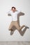 Full length picture of joyful guy in shirt and trousers jumping