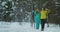 Full length portrait of active young couple enjoying skiing in snowy winter forest, focus on smiling woman in front