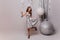 Full-length portrait of adorable dancing woman isolated on light background. Charming female model in sparkle dress