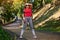 Full length portrait athlete woman, runner wiping the sweat from her face using terry wristband while running in city park,