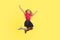 Full length portrait of beautiful little girl with long blond hair in dress jumping in air, inspired child flying