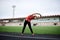 Full-length portrait of blond woman, doing stretching exercises on a stadium in summer, Fit sportswoman, wearing black leggings