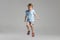 Full-length portrait of Caucasian little boy posing isolated over gray studio background.