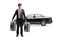 Full length portrait of a chauffeur in a uniform carrying suitcases in front of a black car