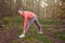 Full length portrait of a cheerful fit young woman doing stretching