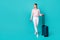 Full length portrait of cheerful nice person look empty space hold suitcase isolated on vibrant emerald color background