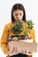 Full length portrait of confused young woman dressed in elegant wear holding box with office supplies due to firing