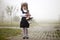 Full-length portrait of cute adorable first grader girl in school uniform and white bows with flowers basket composition standing