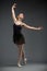 Full-length portrait of dancing ballerina with outstretched arms