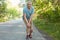 Full length portrait of displeased male pensioner, leans on knees, has pain after jogging, banged his leg, stands on road in rural