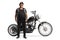 Full length portrait of an elderly biker with a leather vest and a custom chopper