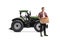 Full length portrait of a farmer with a wooden crate full of apples standing in front of a tractor