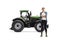 Full length portrait of a female farmer posing with crossed arms in front of a tractor