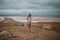 Full-length portrait of a girl in shorts and a white bodysuit on the background of a salty pink lake