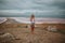 Full-length portrait of a girl in shorts and a white bodysuit on the background of a salty pink lake