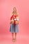 Full length portrait of gorgeous blonde lady with stack of holiday presents on pink studio background. Woman's Day