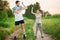 Full length portrait of handsome father and little daughter showing their muscles, looking at camera and smiling outdoor