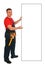 Full length portrait of an happy caucasian construction worker pointing something on an blank billboard. Smiling handsome plumber.