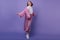 Full-length portrait of inspired young lady in fashionable clothes posing on purple background. Joc