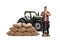 Full length portrait of a male farmer with a shovel standing in front of a tractor