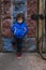 Full length portrait of an mixed race little boy standing on a dirty city street