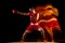 Full-length portrait of one professional boxer in red uniform training isolated over black background. Straight punch