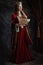 Full length portrait of pensive medieval queen in red dress