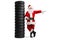 Full length portrait of santa claus leaning on a pile of tires and pointing to the side