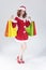 Full Length Portrait of Smiling Caucasian Ginger Santa Helper Girl with Plenty of Colorful Shopping Bags
