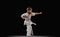 Full-length portrait of sportive little boy training karate, judo, taekwondo sport isolated over black background