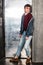 Full length portrait of stylish young fashion model man in bright red sunglasses and denim casual style posing near metallic door