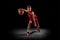 Full-length portrait of teen boy, professional backetball player in motion, training isolated over black background