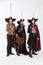 Full-length portrait of thee men in vitage costumes with swords, musketeer and pirate isolated over white background