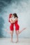 Full-length portrait of two tenderly embracing women dressed in identical red dresses. Lesbian intimacy.