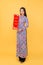 Full-length portrait of Vietnamese girl in ao-dai dress showing