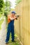 Full-length portrait of worker constructing wooden fence