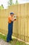 Full-length portrait of worker constructing wooden fence