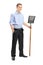 Full length portrait of a young man holding a shovel