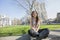 Full length portrait of young woman sitting against Westminster Abbey in London, England, UK