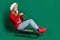 Full length profile photo of crazy santa young lady slide on sled wear sweater jeans boots isolated on green background