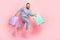 Full length profile portrait of crazy person arms hold suitcase hurry jump isolated on pink color background