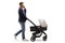 Full length profile shot of a father pushing a baby carriage and making a phone call