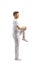 Full length profile shot of a guy in white clothes streching leg