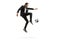 Full length profile shot of a man in a black suit kicking a soccer ball