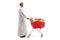 Full length profile shot of a man in ethnic clothes pushing a shopping trolley with food and red ribbon bow