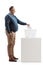 Full length profile shot of a mature man casting a vote in a ballot box