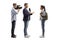 Full length profile shot of a reporter with a microphone and a cameraman interviewing a female student