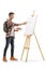 Full length profile shot of a teenage boy painting on a canvas